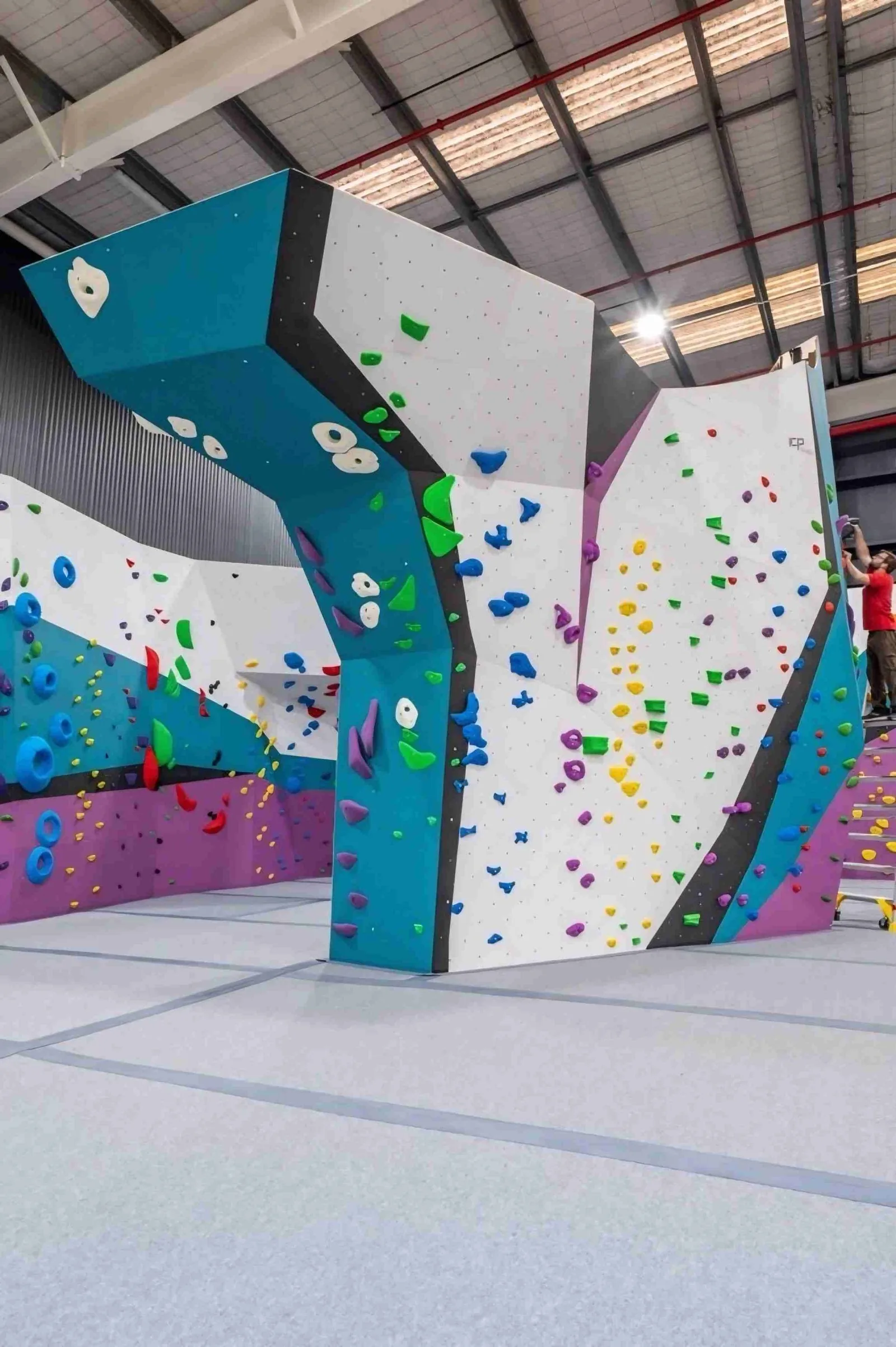 A climber reaching for a hold on a bouldering wall